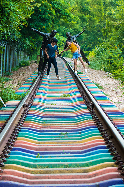 The lovers walking on the colorful rainbow style railway in Changping Town Railway Park of Dongguan