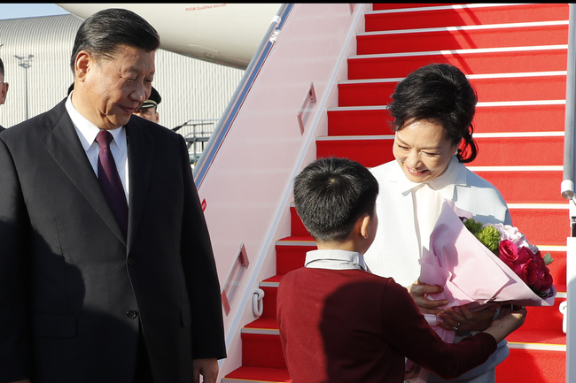 1_A esposa do Presidente, Peng Liyuan, recebe ramos de flores dos alunos de escolas primárias de Macau, à chegada ao Aeroporto Internacional de Macau.